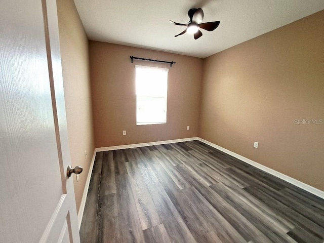 empty room featuring dark wood-type flooring and ceiling fan