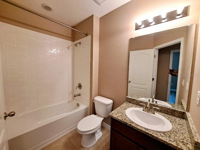 full bathroom with tiled shower / bath, vanity, toilet, tile patterned floors, and a textured ceiling