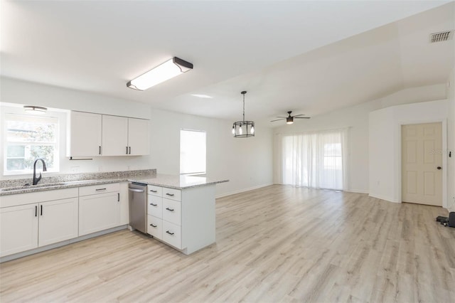 kitchen with white cabinetry, sink, light stone counters, and kitchen peninsula