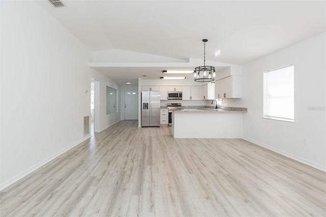 kitchen with appliances with stainless steel finishes, white cabinetry, sink, hanging light fixtures, and kitchen peninsula