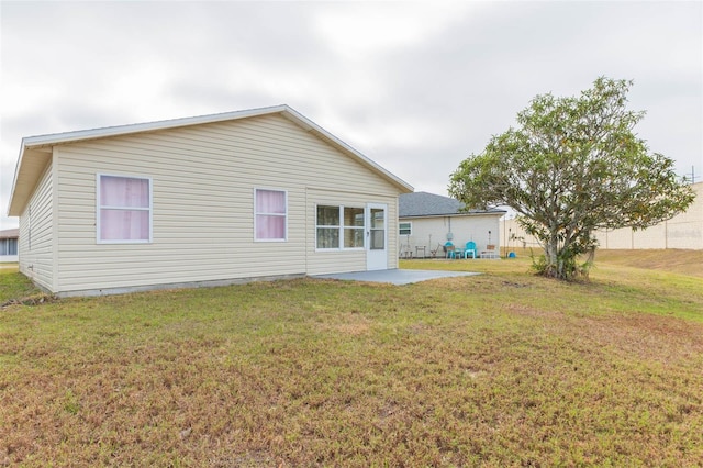 back of house featuring a yard and a patio