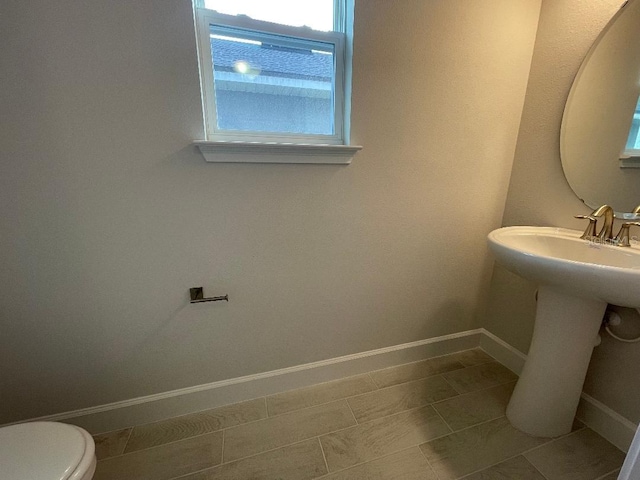 bathroom featuring sink, toilet, tile patterned flooring, and a wealth of natural light