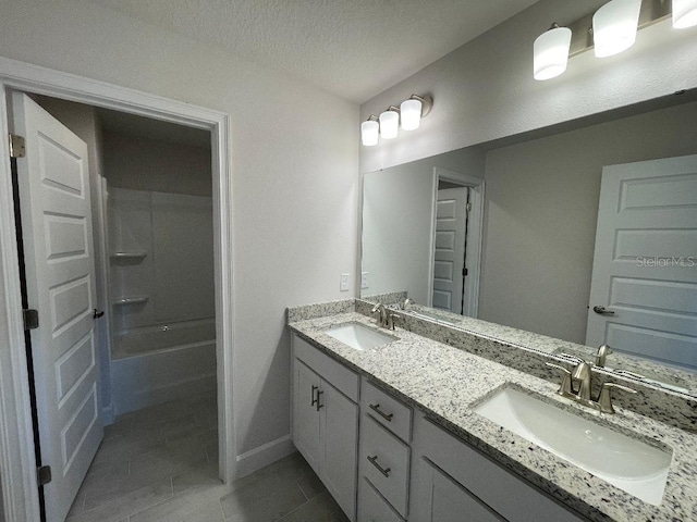 bathroom with vanity, tile patterned flooring, shower / washtub combination, and a textured ceiling