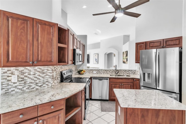 kitchen with appliances with stainless steel finishes, tasteful backsplash, sink, light tile patterned floors, and ceiling fan