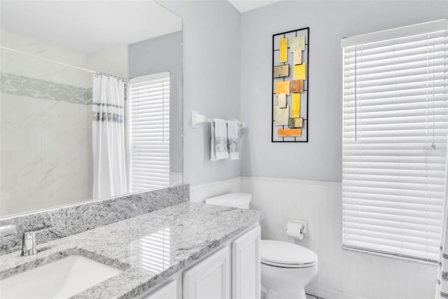 bathroom with vanity, toilet, and curtained shower