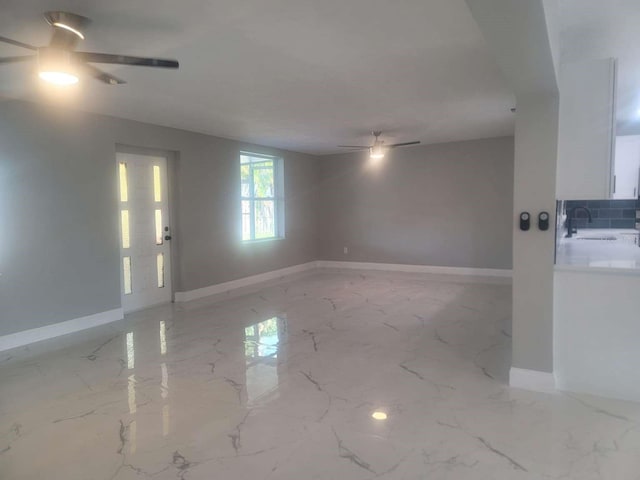 unfurnished room with sink and ceiling fan