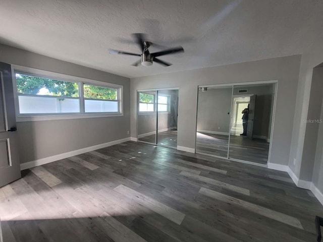 unfurnished bedroom featuring ceiling fan, dark hardwood / wood-style flooring, and a textured ceiling