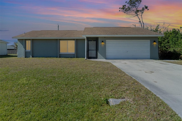 ranch-style house featuring a garage and a lawn