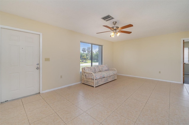 interior space featuring light tile patterned floors, a textured ceiling, and ceiling fan