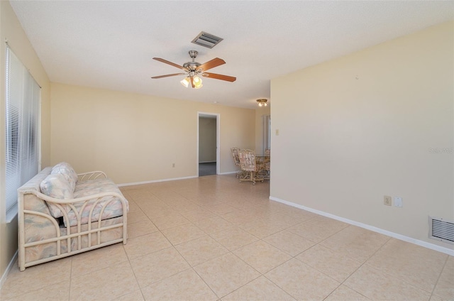 living area with light tile patterned floors and ceiling fan