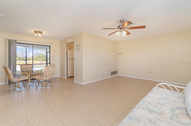 interior space with a textured ceiling and ceiling fan