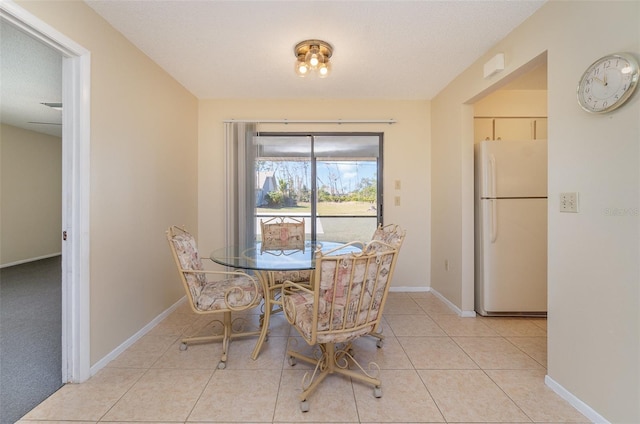 dining area with light tile patterned floors and a textured ceiling