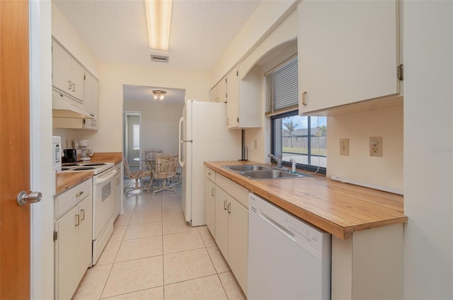 kitchen featuring white cabinetry, sink, white appliances, and light tile patterned floors