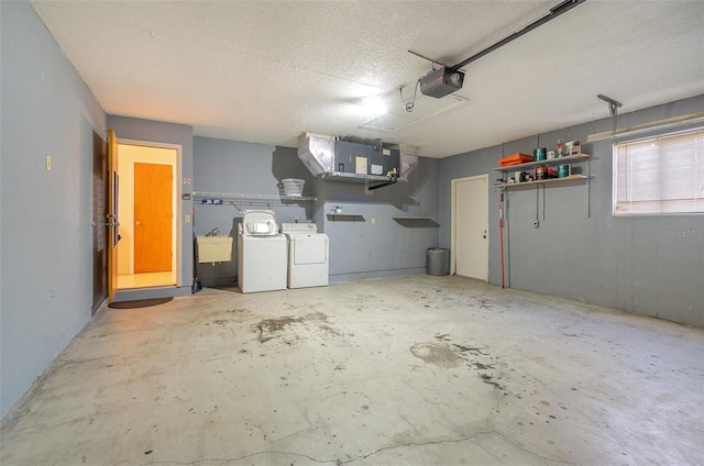 garage featuring a garage door opener, washer and dryer, and sink