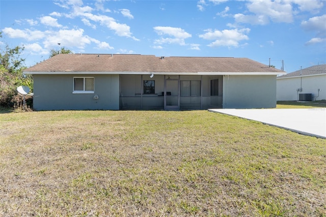 rear view of property with a yard and central air condition unit