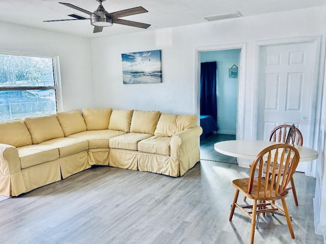 living room featuring wood-type flooring and ceiling fan