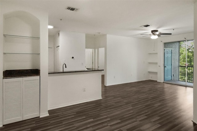 unfurnished living room with dark hardwood / wood-style floors, sink, and ceiling fan