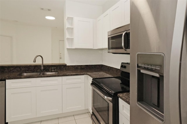 kitchen featuring white cabinetry, appliances with stainless steel finishes, sink, and dark stone countertops