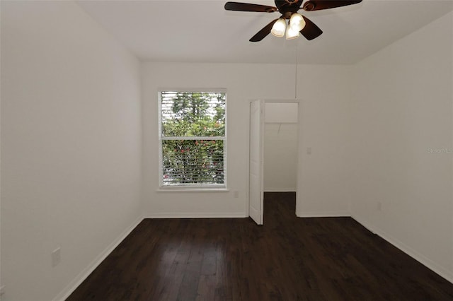 spare room featuring dark hardwood / wood-style flooring and ceiling fan