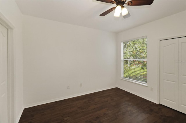 unfurnished bedroom featuring dark hardwood / wood-style flooring, a closet, and ceiling fan