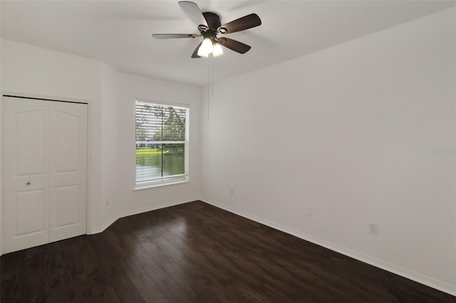 unfurnished bedroom featuring dark wood-type flooring, ceiling fan, and a closet