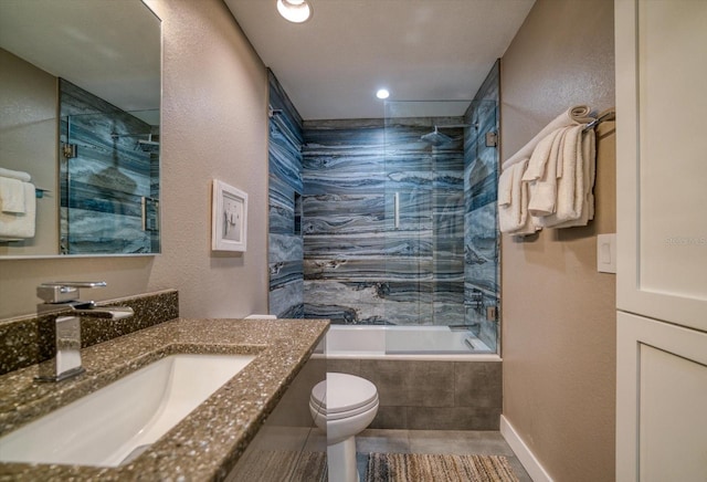 full bathroom featuring tiled shower / bath, vanity, and toilet