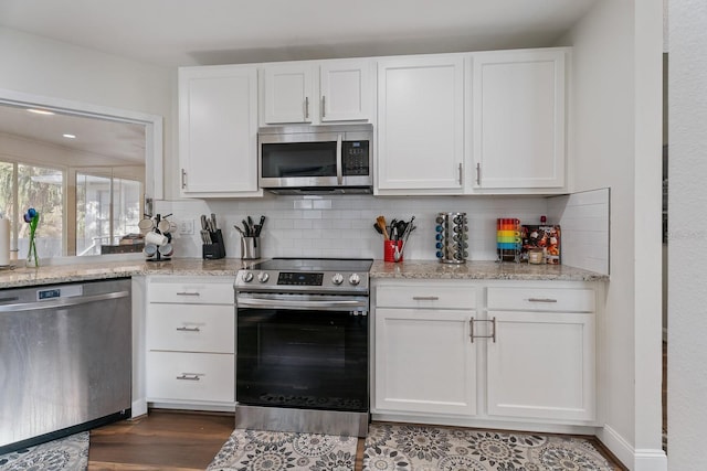 kitchen with appliances with stainless steel finishes, decorative backsplash, and white cabinets