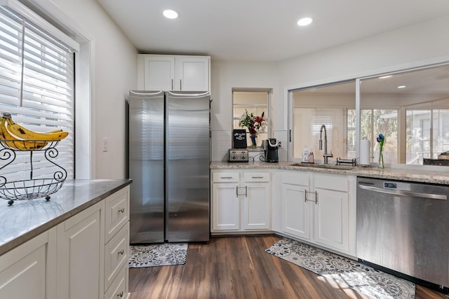 kitchen featuring light stone counters, stainless steel appliances, sink, and white cabinets