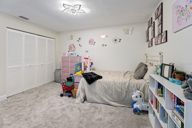 carpeted bedroom featuring a closet and a textured ceiling