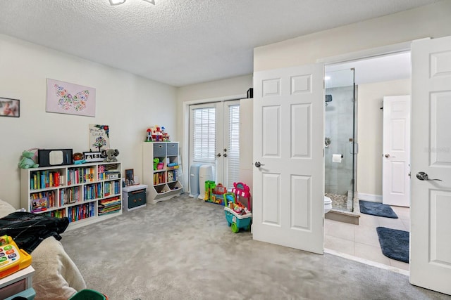 rec room with light colored carpet and a textured ceiling