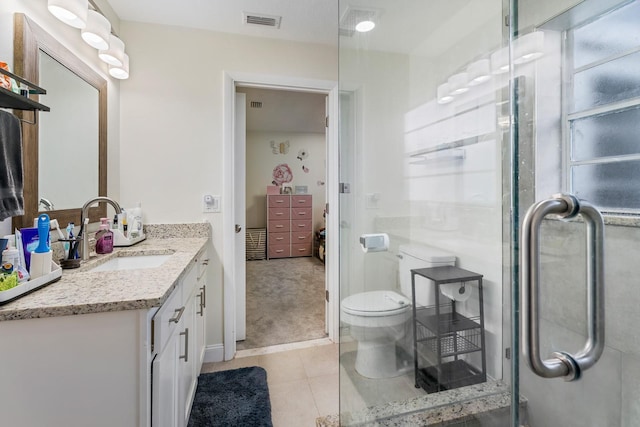 bathroom featuring vanity, tile patterned flooring, a shower with door, and toilet