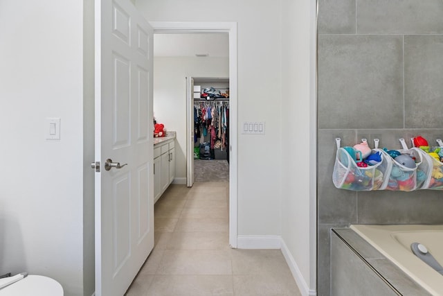 bathroom with vanity, tile patterned flooring, and a washtub