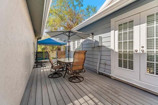 wooden deck with a trampoline and french doors