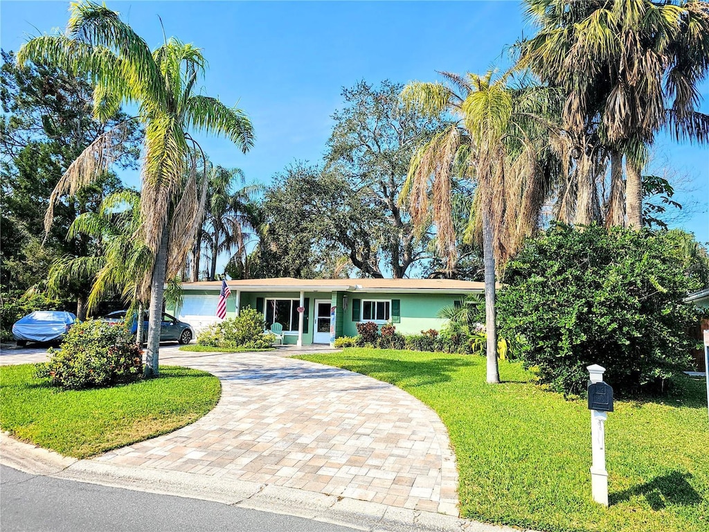 single story home featuring a garage and a front lawn