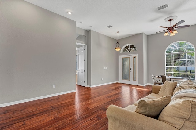 living room with dark hardwood / wood-style floors, a textured ceiling, and ceiling fan