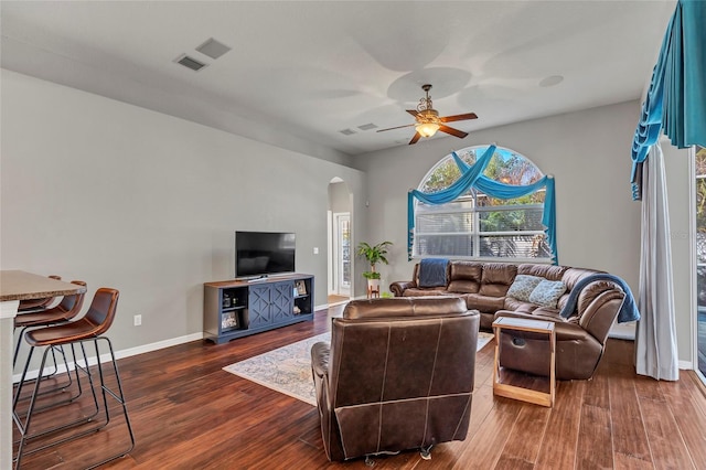 living room with dark wood-type flooring and ceiling fan