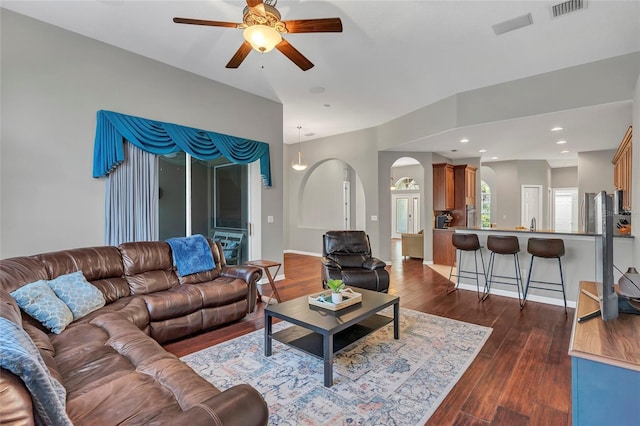 living room featuring dark hardwood / wood-style flooring and ceiling fan