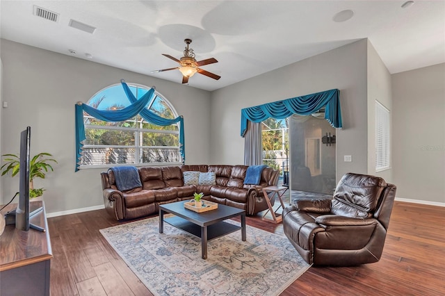 living room featuring ceiling fan and dark hardwood / wood-style flooring