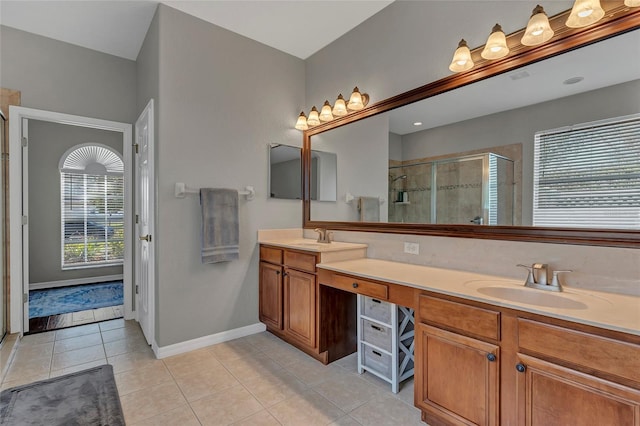 bathroom with tile patterned flooring, vanity, and walk in shower