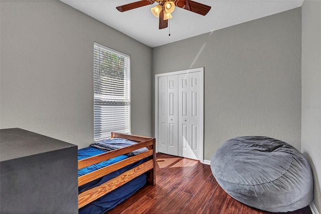 bedroom featuring dark hardwood / wood-style flooring, a closet, and ceiling fan