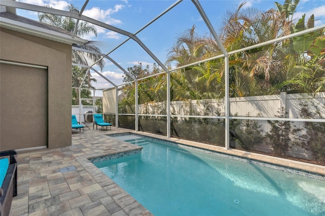 view of pool with a patio area and glass enclosure