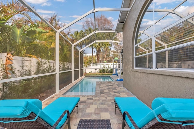 view of swimming pool featuring a lanai and a patio area