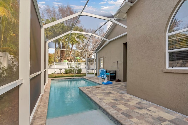 view of pool with a patio and glass enclosure