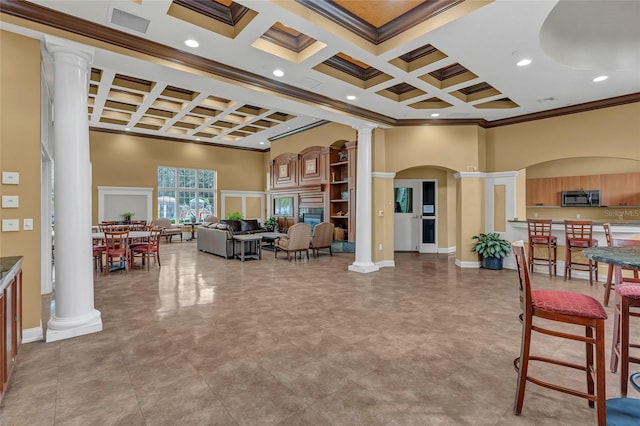 interior space featuring crown molding, a towering ceiling, coffered ceiling, and ornate columns