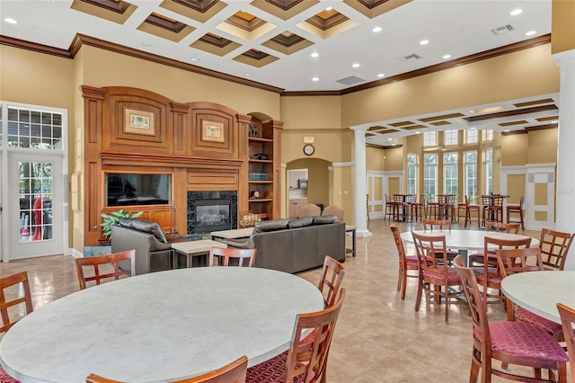 dining area featuring ornate columns, a healthy amount of sunlight, and a towering ceiling