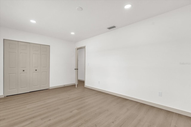 unfurnished bedroom featuring a closet and light hardwood / wood-style flooring