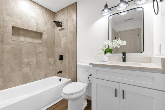 full bathroom with vanity, tiled shower / bath combo, toilet, and hardwood / wood-style flooring