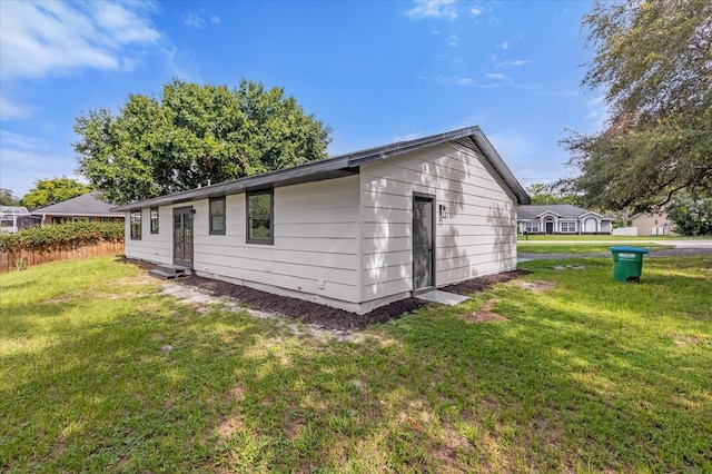 rear view of property featuring a lawn