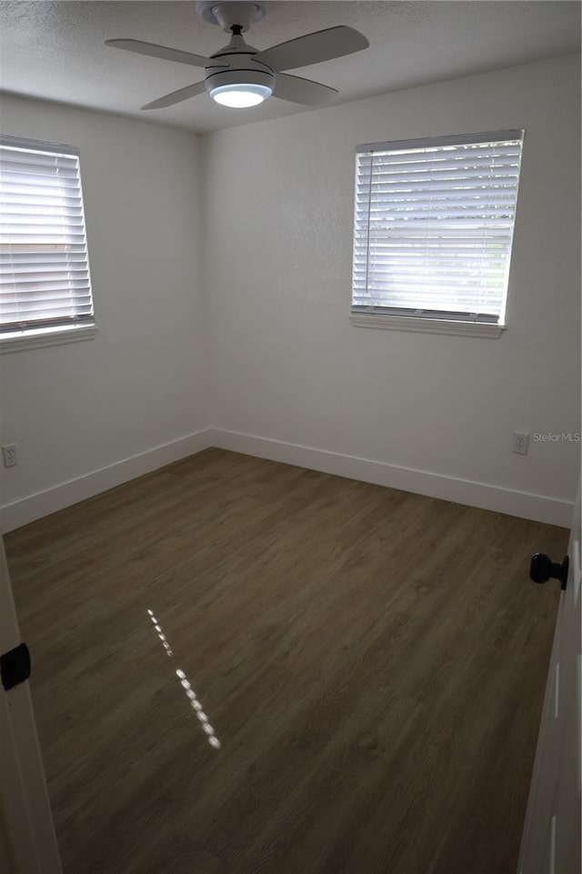 empty room with plenty of natural light and baseboards