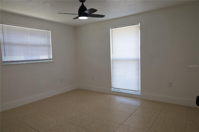 unfurnished room featuring light tile patterned flooring, ceiling fan, and a textured ceiling